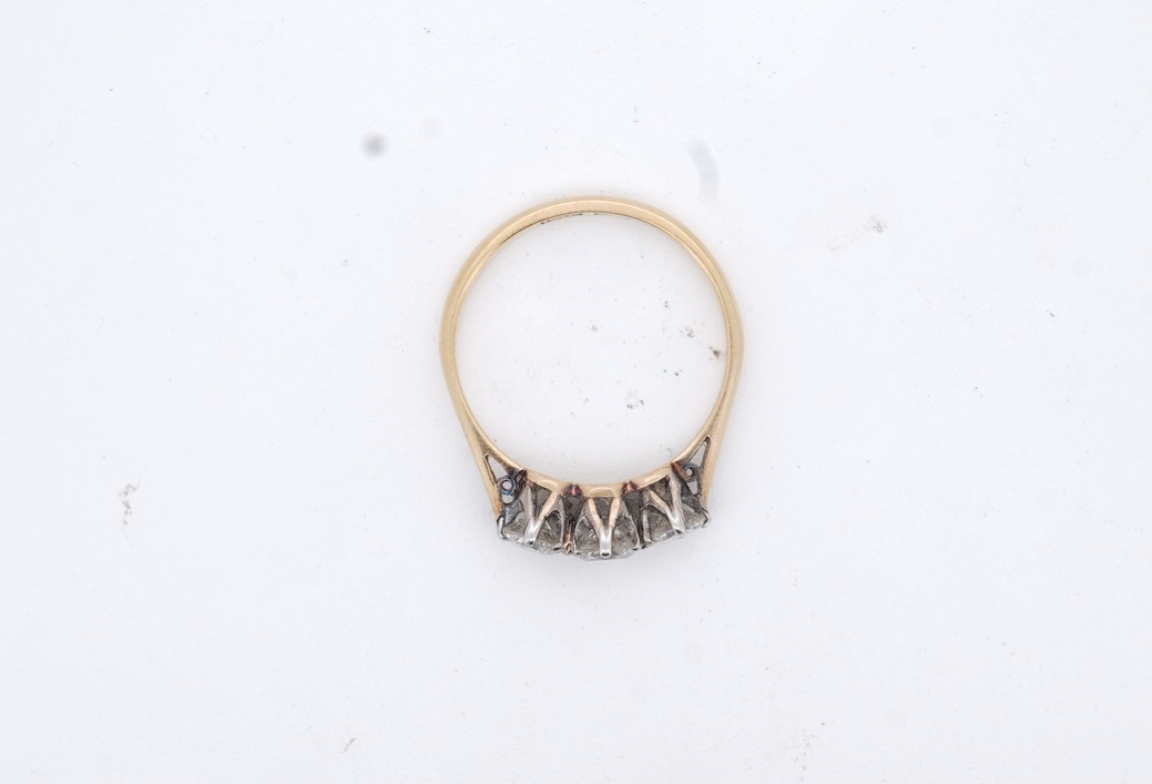 A yellow metal (stamped 18ct, & plat) and three stone diamond set ring, size L, gross weight 2.1 grams.